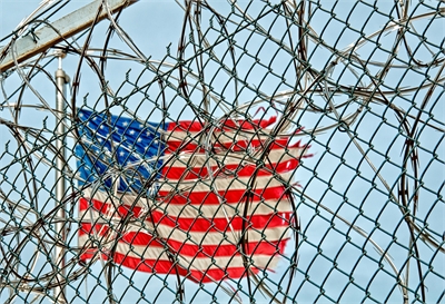 American flag behind barbed wire American flag behind barbed wire